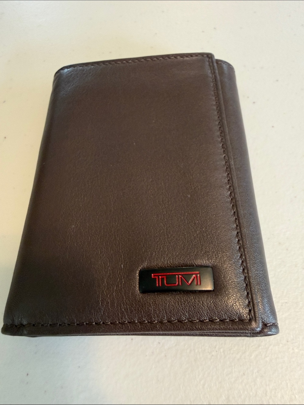 Tumi Brown Leather Tri-Fold Wallet with Red Logo Accent